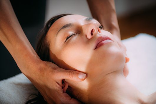 Cranial osteopathy massage. Therapist massaging woman’s head.